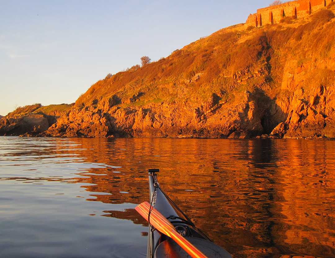 Glødende varme klipper på din kajaktur. En illusion i solens sidste timer på vestkysten, sammen med kajakeksperten